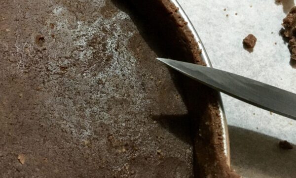 Fond de tarte au cacao dont le bord est égalisé au couteau