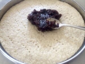 Confiture de framboises étalée sur le fond de tarte