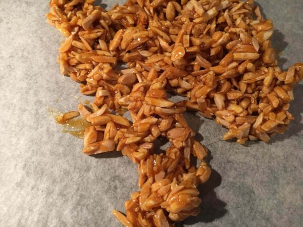 Amandes caramélisées étalées sur une feuille de cuisson