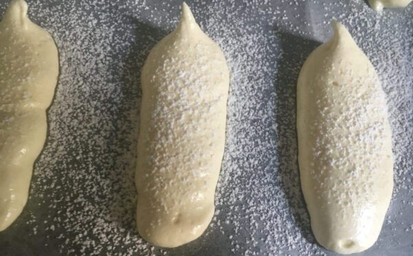 Biscuits à la cuillère dressés, saupoudrés de sucre glace avant cuisson