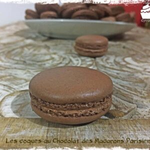 Coques de macarons au chocolat superposées, avec une assiette derrière