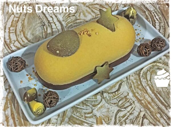 Bûche Nuts Dreams jaune décorée dans un plat