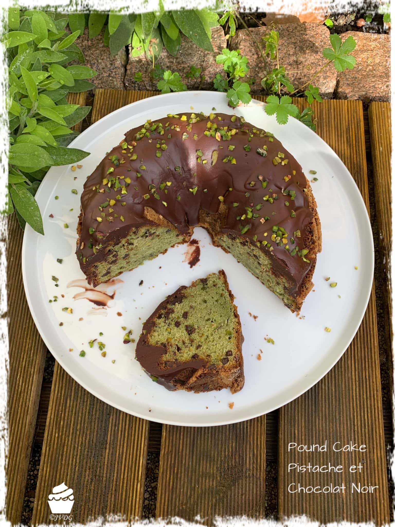 Cake à la pistache glacé au chocolat noir et tranche sur une assiette