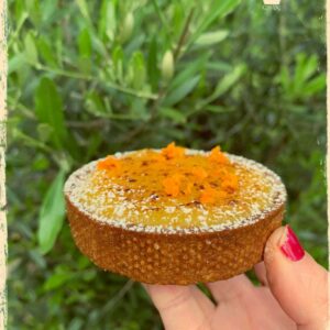 Tartelette à l’orange présentée de côté dans une main