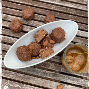 Assiette de rochers amande coupés et pot de praliné sur une table