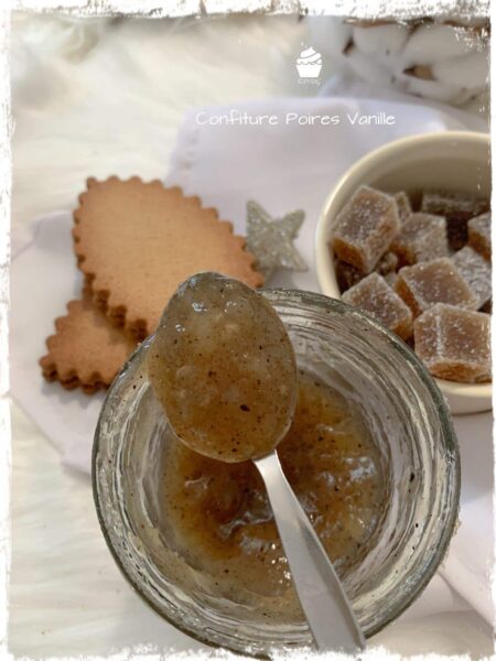 Cuillère de confiture de poire et vanille au-dessus du pot, biscuits à côté