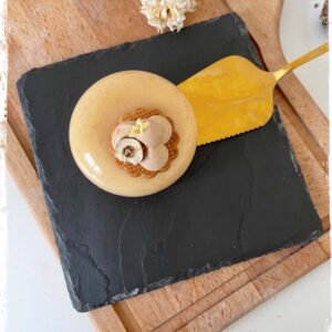 Entremets Romy sur une ardoise près d’une pelle à gâteau