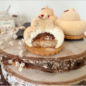 Entremets 9 mois miel fraise noisette entamé sur un rondin