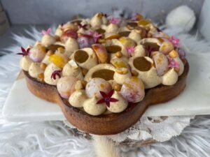 Tarte mirabelle, pécan et Dulcey en forme de fleur, décorée de ganache et fruits