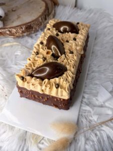 Bûche Sur un air d’été au glaçage rocher et décor de quenelles chocolatées