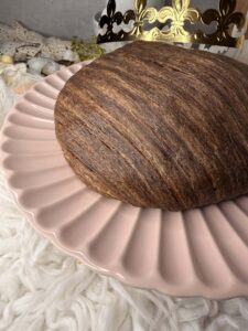 Galette des rois striée chocolat noisette entière sur une assiette rose