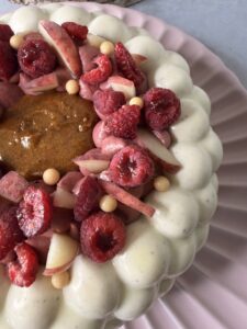 Détail des framboises, pêches et ganache rose sur Melba